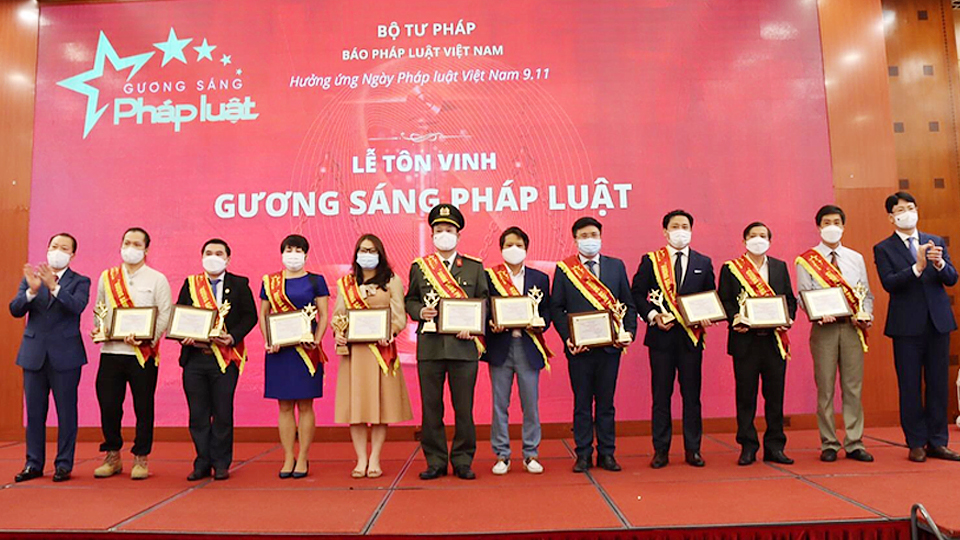 Thứ trưởng Nguyễn Thanh Tịnh (ngoài cùng bìa phải) và Tổng Biên tập Báo Pháp luật Việt Nam Đào Văn Hội (ngoài cùng bìa trái) trao Giấy chứng nhận của Chương trình “Gương sáng Pháp luật” cho các Gương sáng Pháp luật 2021.