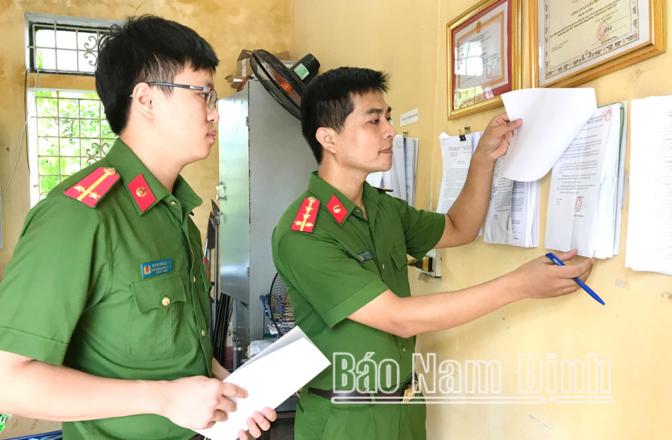 Đại úy Trần Văn Hoàn, Trưởng Công an xã Liên Minh, huyện Vụ Bản (bên phải) trao đổi kế hoạch công tác với đồng nghiệp. Bài và ảnh: Xuân Thu
