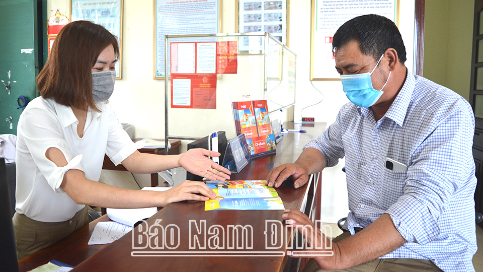Cán bộ Quỹ Tín dụng nhân dân Ninh Vân (Xuân Trường) hướng dẫn người dân sử dụng dịch vụ chuyển tiền điện tử CF-eBank.