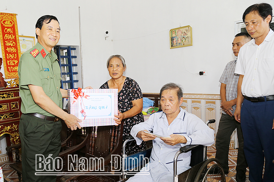 Đồng chí Đại tá Trần Minh Tiến, Giám đốc Công an tỉnh thăm, tặng quà bà Nguyễn Thị Tẹo, sinh năm 1935 ở xóm 5, xã Nghĩa Trung.