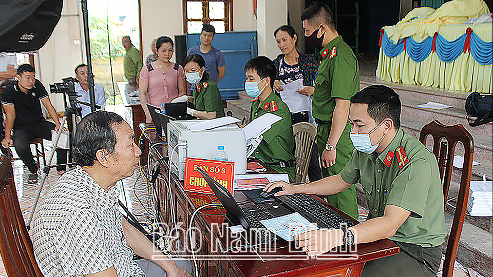 Cán bộ, chiến sĩ Đội Cảnh sát quản lý hành chính về trật tự xã hội (Công an huyện Nam Trực) làm thủ tục cấp thẻ căn cước công dân gắn chíp điện tử cho nhân dân thị trấn Nam Giang.