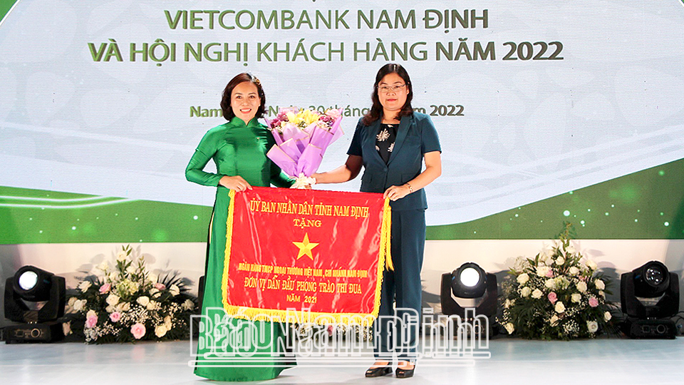 Đồng chí Hà Lan Anh, TUV, Phó Chủ tịch UBND tỉnh thay mặt UBND tỉnh trao Cờ thi đua năm 2021 cho Vietcombank Nam Định.