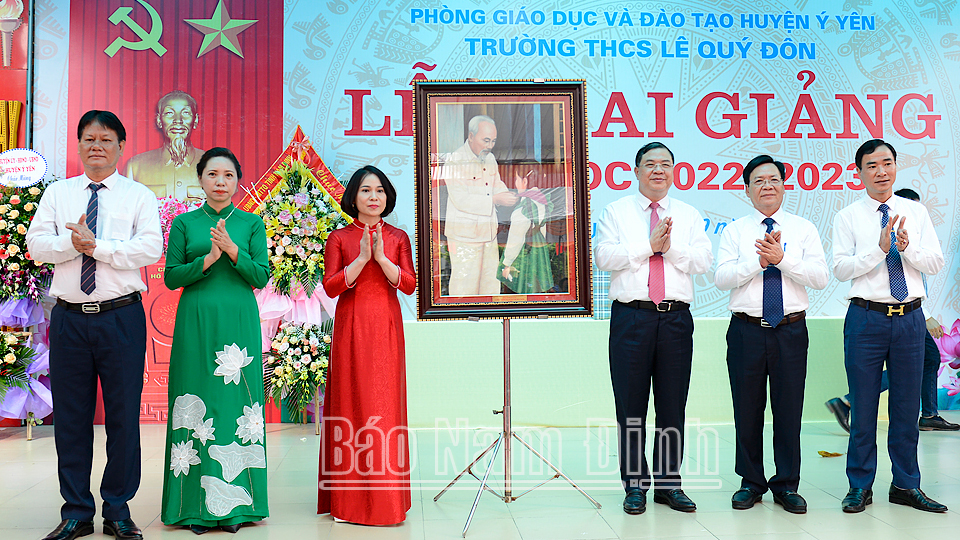 Đồng chí Bí thư Tỉnh ủy Phạm Gia Túc và lãnh đạo Sở Giáo dục và Đào tạo, lãnh đạo huyện Ý Yên tặng tập thể Trường THCS Lê Quý Đôn bức ảnh Bác Hồ quàng khăn đỏ cho thiếu niên, nhi đồng.