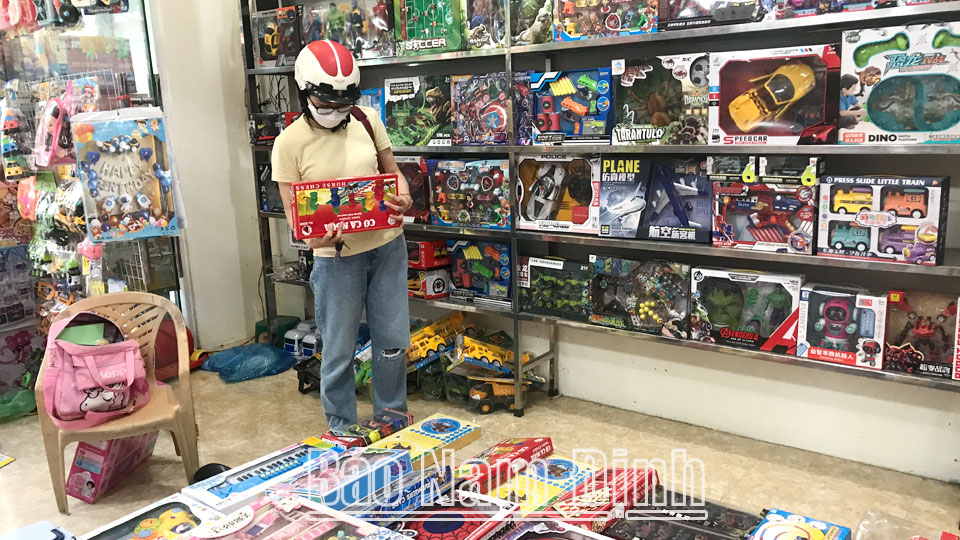 Phụ huynh chọn mua đồ chơi cho trẻ em tại một cửa hàng trên đường Trần Phú (thành phố Nam Định).
