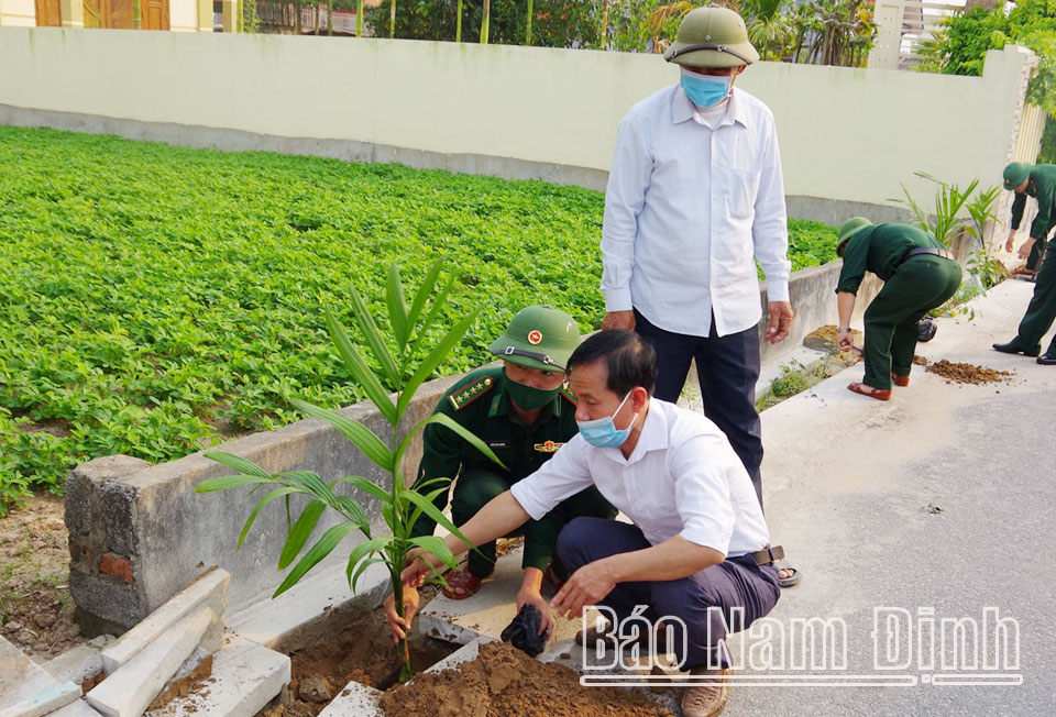 Cán bộ Đồn Biên phòng Quất Lâm cùng nhân dân tổ dân phố Lâm Bình, xã Giao Phong (Giao Thủy) trồng cây xanh tạo cảnh quan môi trường xanh - sạch - đẹp.